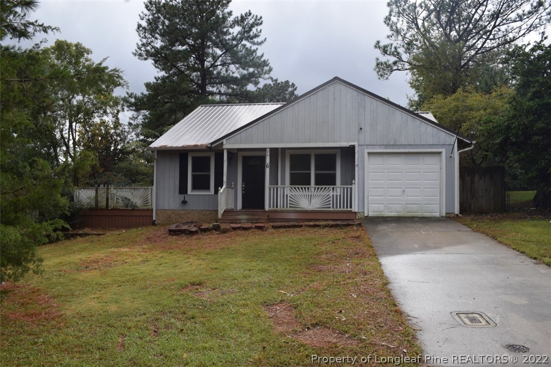 a view of a house with a yard and large tree