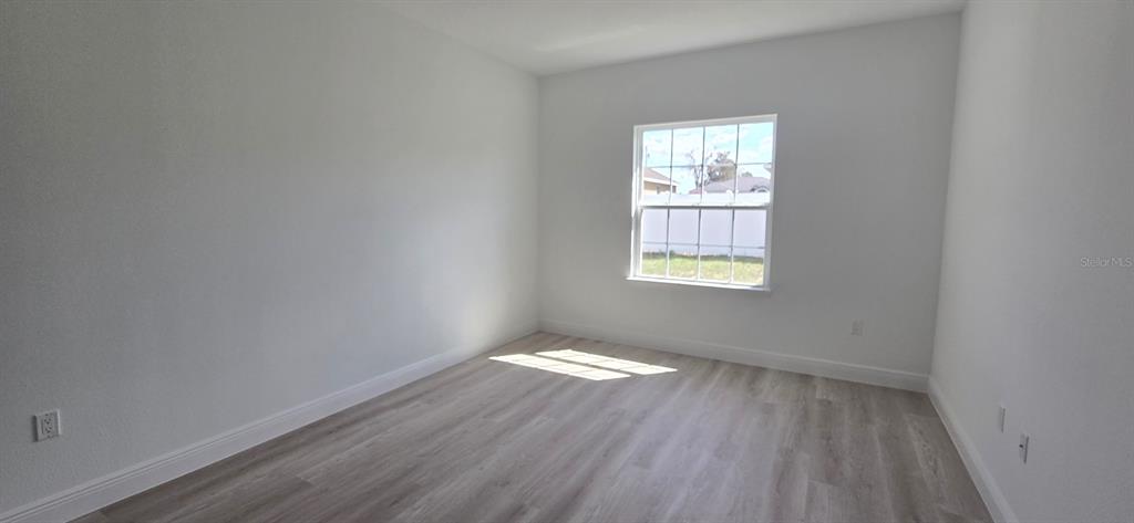 4464 Southwest 132nd Street Ocala, FL 34473 - Photo 12 of 17 an empty room with wooden floor and windows