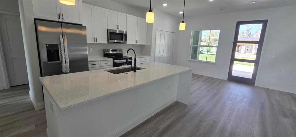 4464 Southwest 132nd Street Ocala, FL 34473 - Photo 5 of 17 a kitchen with stainless steel appliances a refrigerator sink and microwave