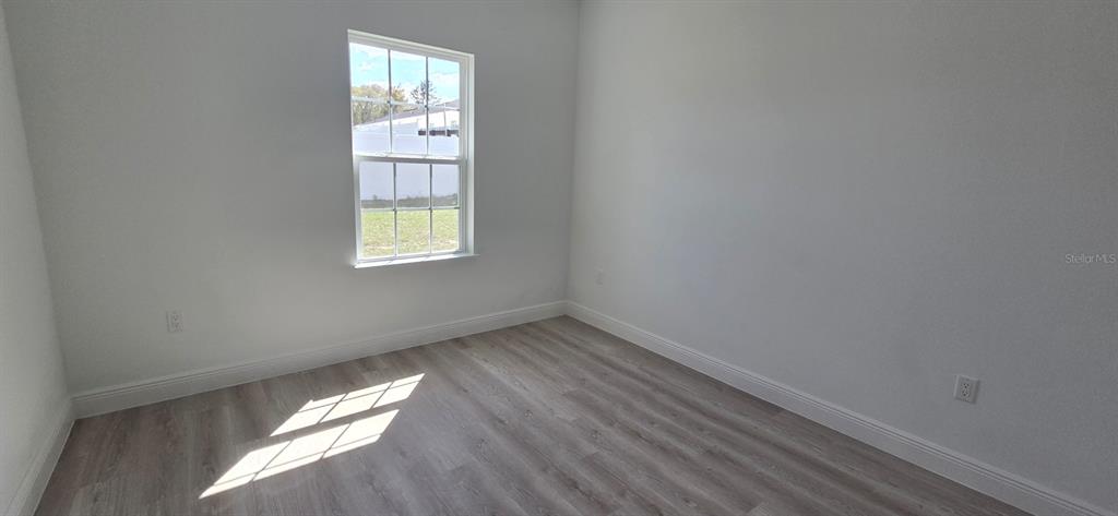 4464 Southwest 132nd Street Ocala, FL 34473 - Photo 8 of 17 an empty room with wooden floor and windows