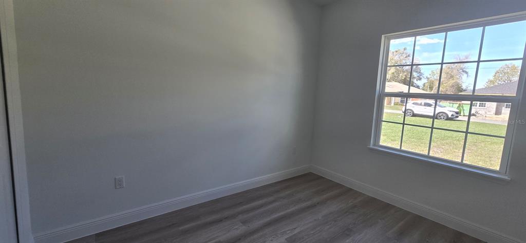 4464 Southwest 132nd Street Ocala, FL 34473 - Photo 10 of 17 an empty room with wooden floor and windows