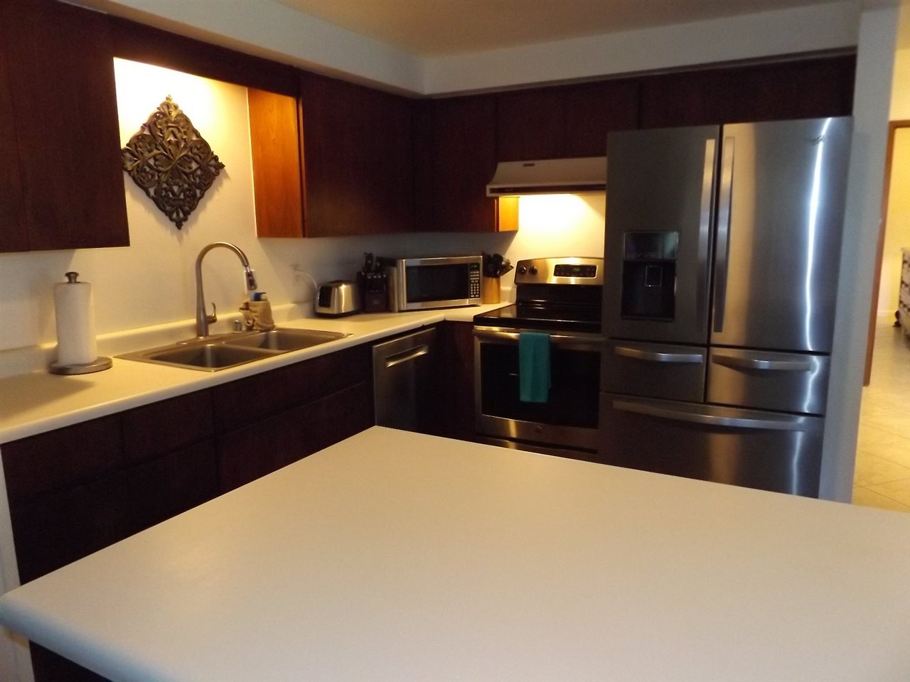 811 South Kihei Road, Unit 5F Kihei, HI 96753 - Photo 3 of 30 a kitchen with stainless steel appliances a sink a stove and a refrigerator