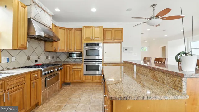 a kitchen with stainless steel appliances granite countertop a sink a stove and a refrigerator