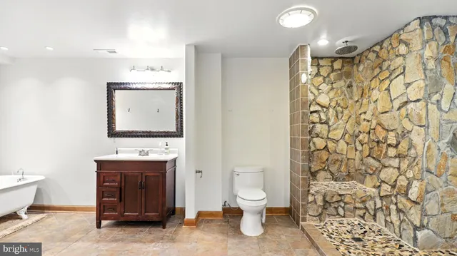 a bathroom with a toilet sink and mirror