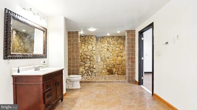 a bathroom with a double vanity sink toilet and shower