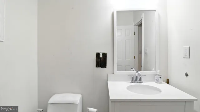 a bathroom with a sink vanity mirror and toilet