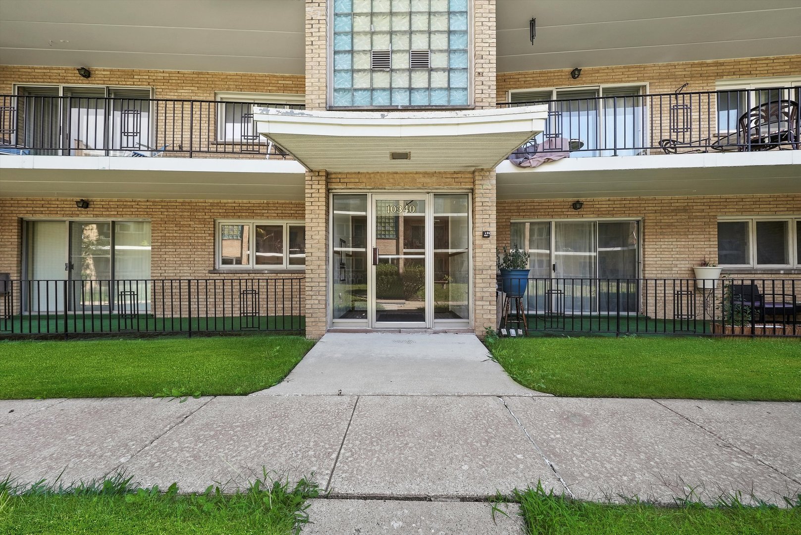 10340 South Pulaski Road, Unit 103 Oak Lawn, IL 60453 - Photo 29 of 30 a view of a brick house with a yard and plants