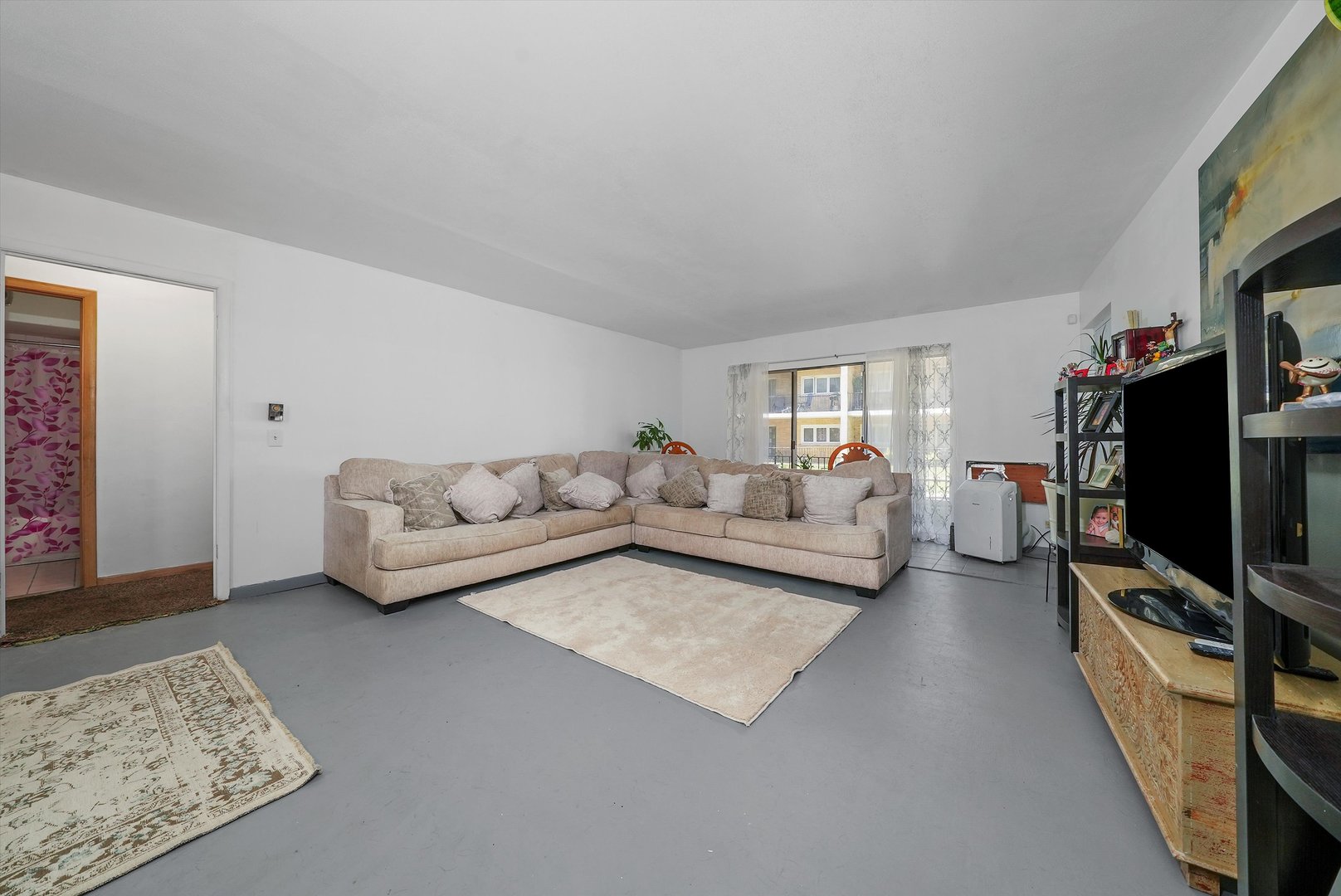 10340 South Pulaski Road, Unit 103 Oak Lawn, IL 60453 - Photo 4 of 30 a living room with furniture and a flat screen tv