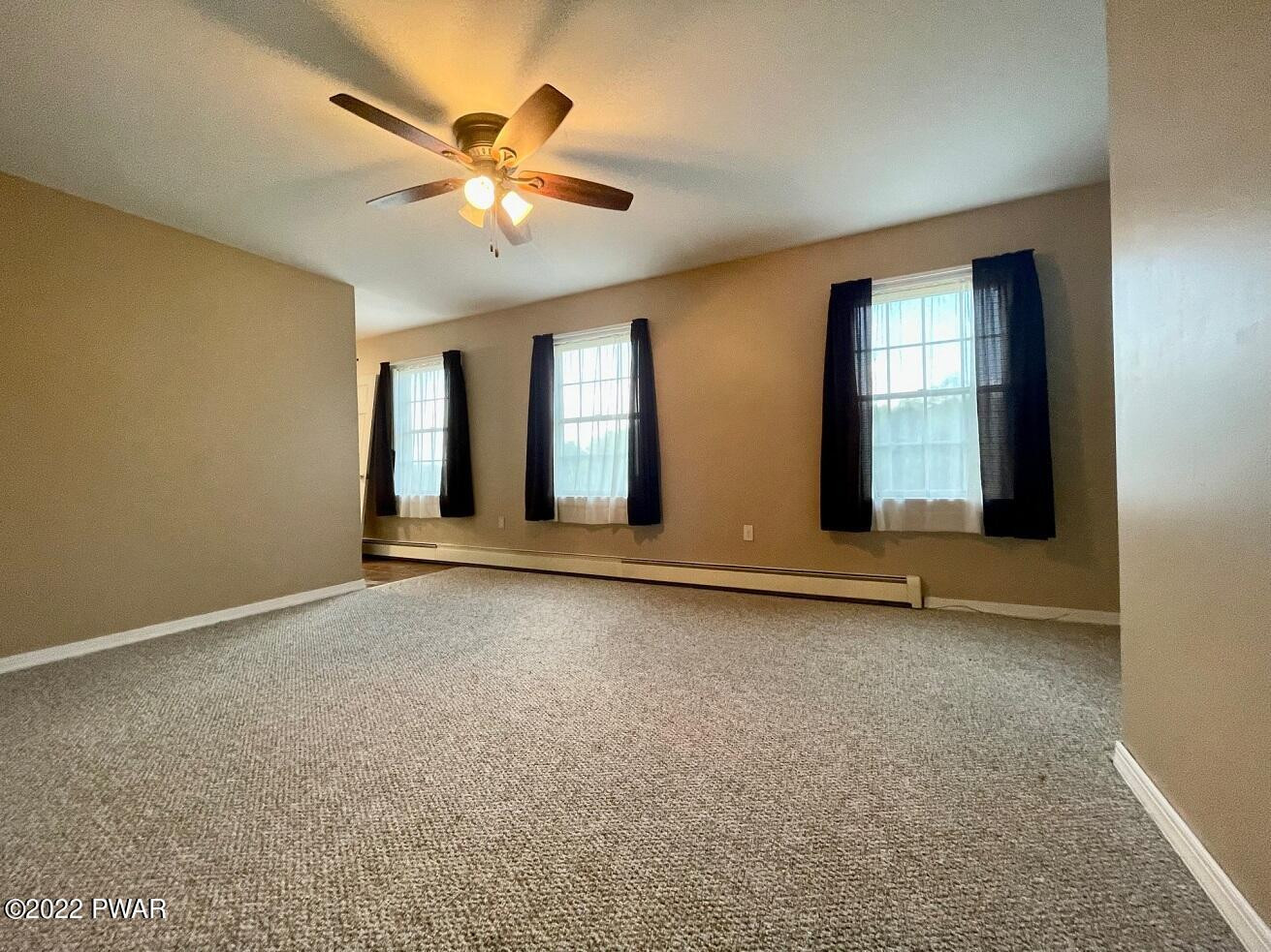 524 Creamton Drive Prompton, PA 18456 - Photo 34 of 57 an empty room with windows and fan