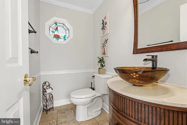 a view of a dining room and livingroom with furniture wooden floor a rug a fireplace and a chandelier