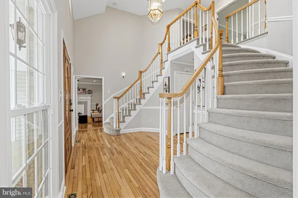 a living room with furniture a chandelier and kitchen view