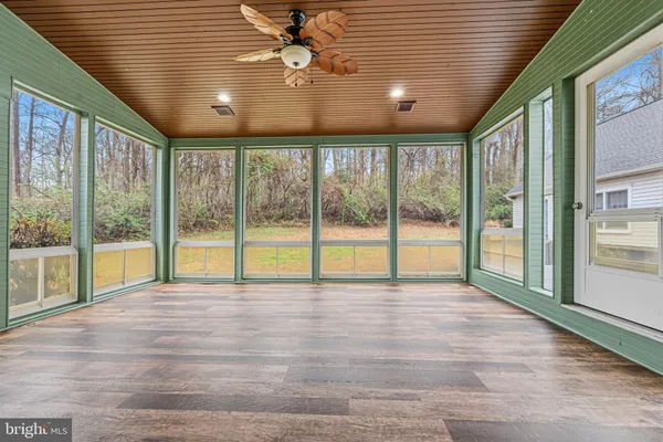 a spacious bathroom with a granite countertop sink toilet a mirror a bathtub and shower