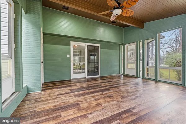 an empty room with windows and ceiling fan