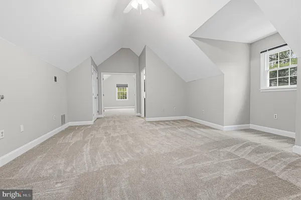 a view of staircase with lots of frames on wall and a window
