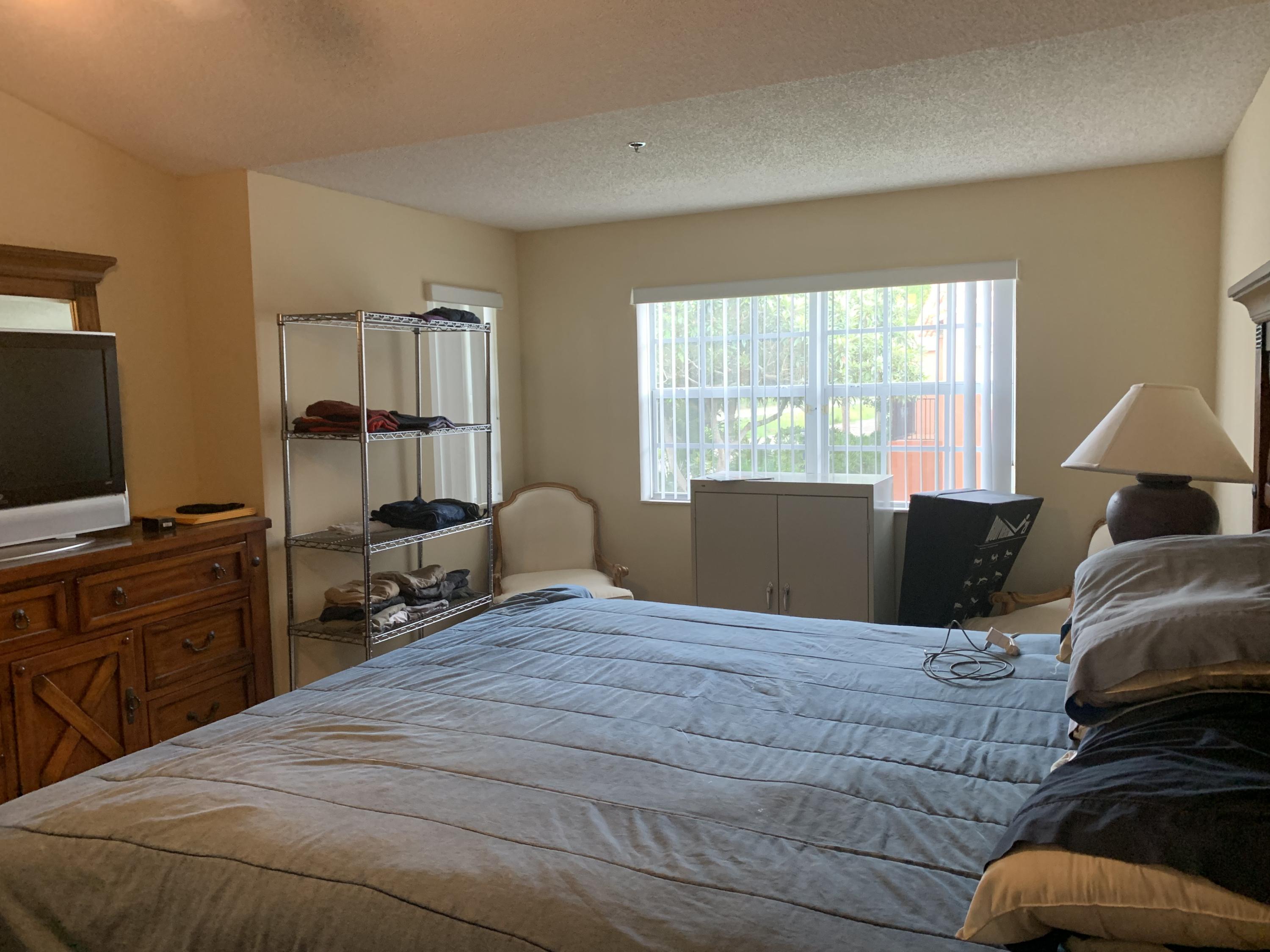 3279 Clint Moore Road, Unit 201 Boca Raton, FL 33496 - Photo 15 of 27 a bedroom with a bed and wooden floor