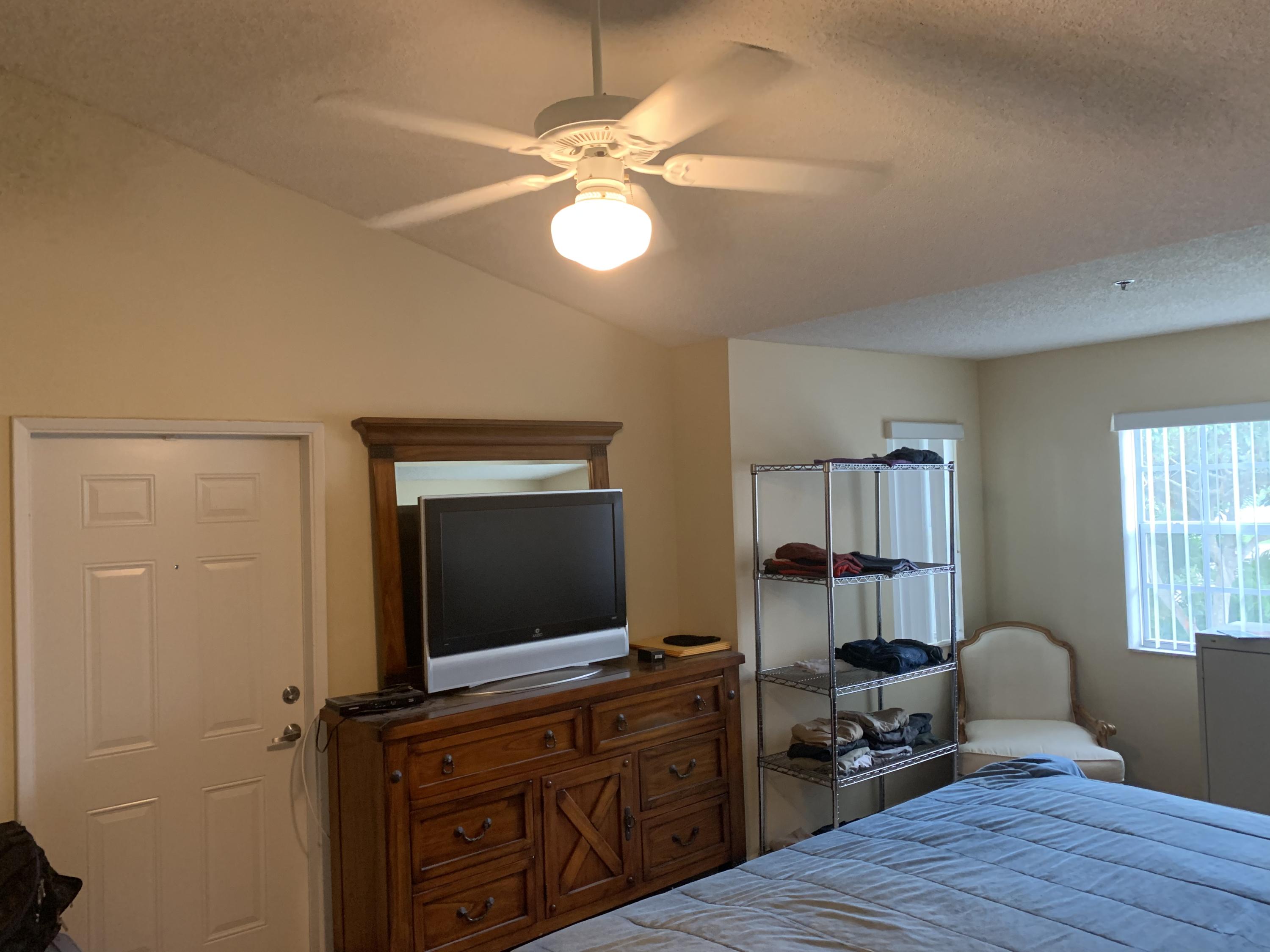 3279 Clint Moore Road, Unit 201 Boca Raton, FL 33496 - Photo 16 of 27 a living room with furniture and a flat screen tv