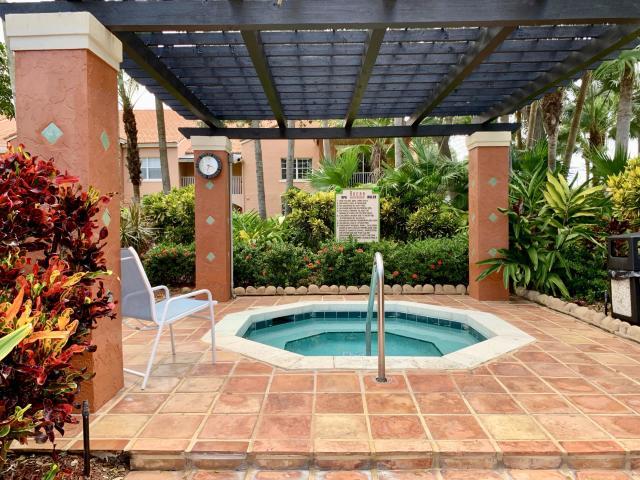 3279 Clint Moore Road, Unit 201 Boca Raton, FL 33496 - Photo 24 of 27 a swimming pool with lawn chairs and potted plants