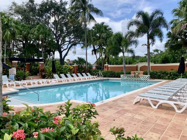 3279 Clint Moore Road, Unit 201 Boca Raton, FL 33496 - Photo 25 of 27 a view of a swimming pool with a lounge chair
