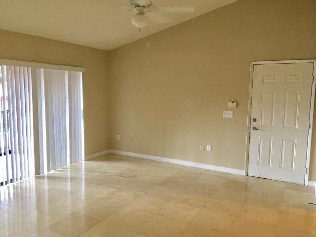 3279 Clint Moore Road, Unit 201 Boca Raton, FL 33496 - Photo 4 of 27 an empty room with wooden floor and windows with curtains