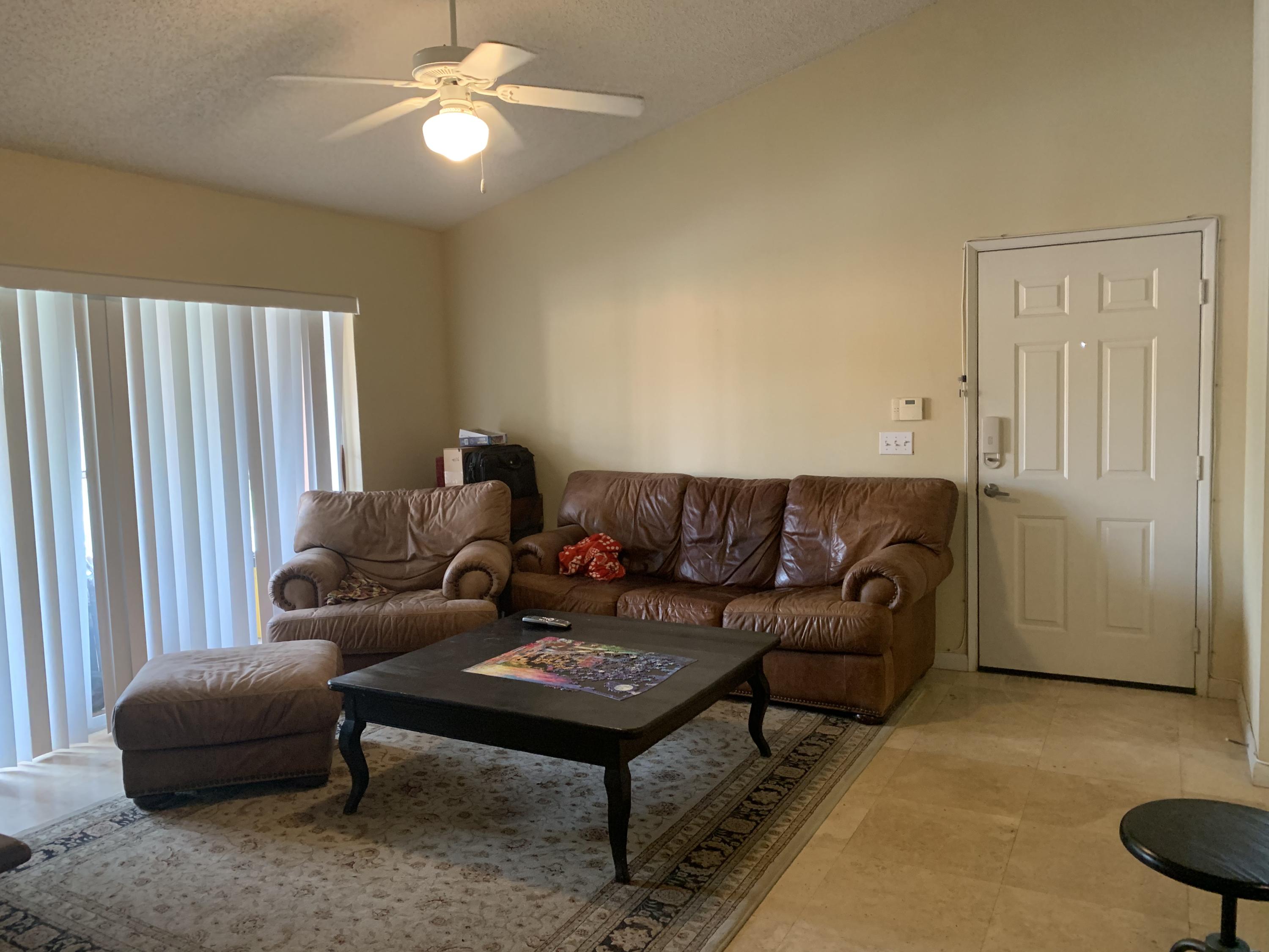 3279 Clint Moore Road, Unit 201 Boca Raton, FL 33496 - Photo 5 of 27 a living room with furniture a ceiling fan and a window