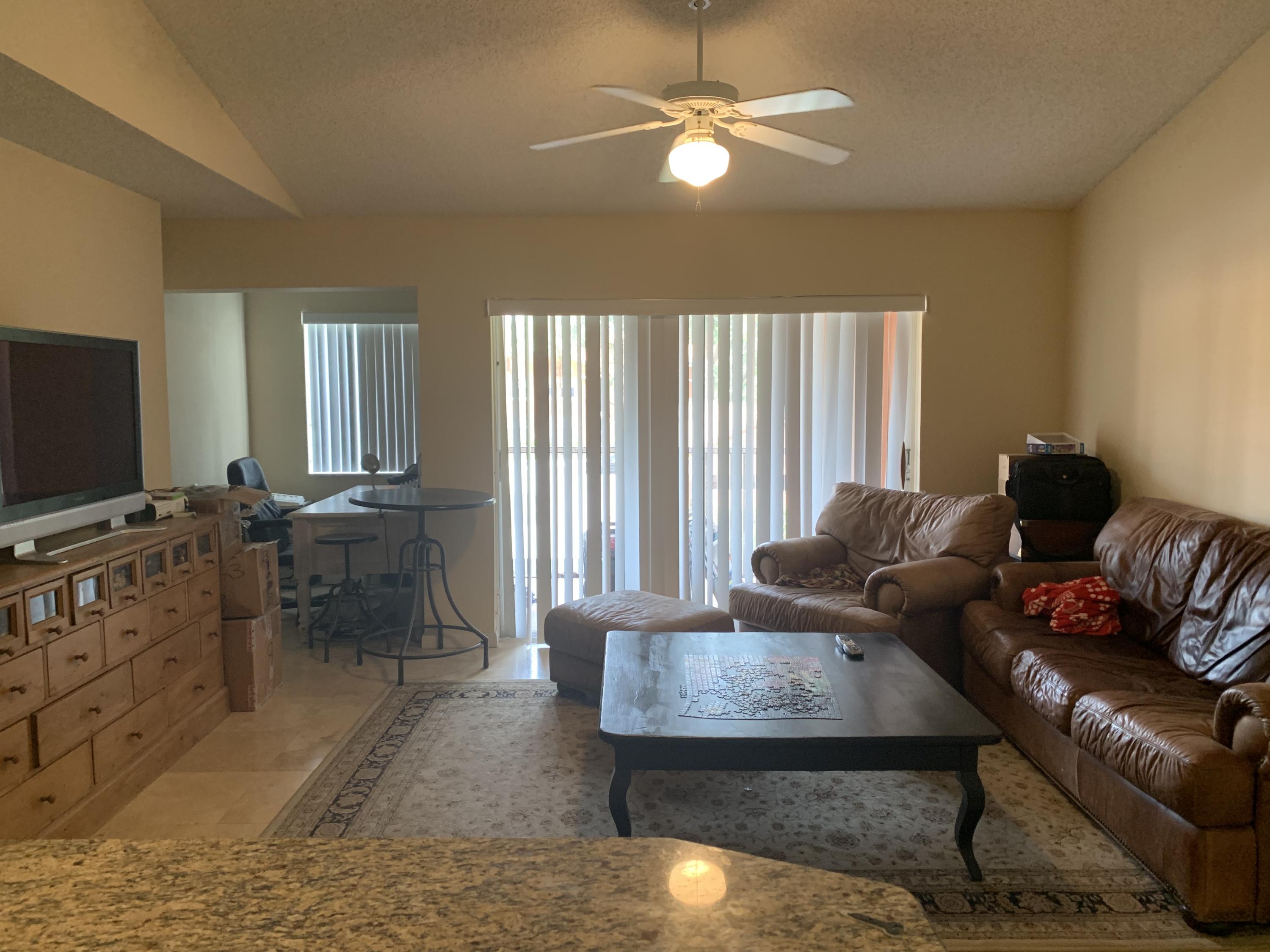 3279 Clint Moore Road, Unit 201 Boca Raton, FL 33496 - Photo 8 of 27 a living room with furniture and a flat screen tv