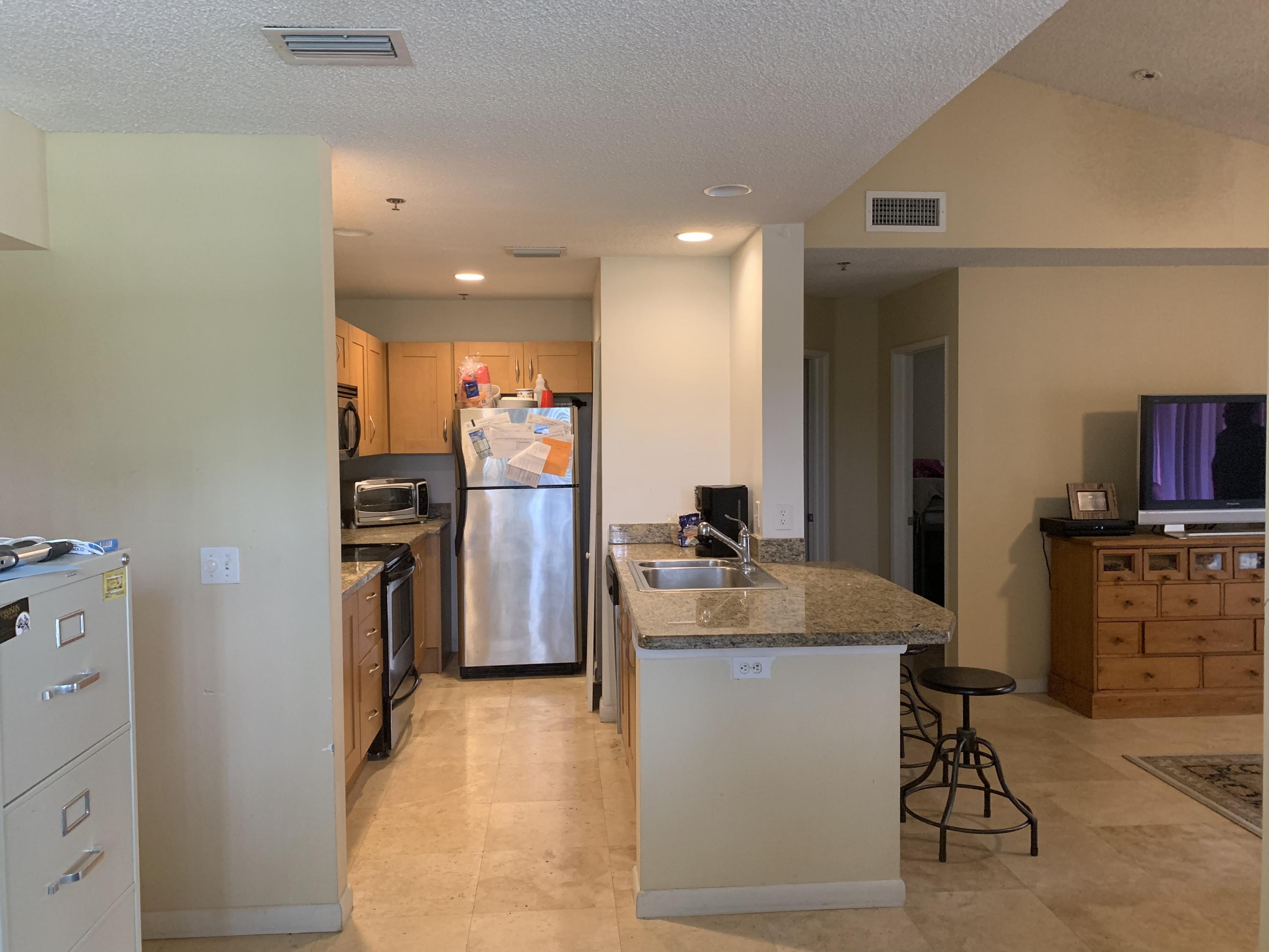 3279 Clint Moore Road, Unit 201 Boca Raton, FL 33496 - Photo 10 of 27 a kitchen with refrigerator and furniture