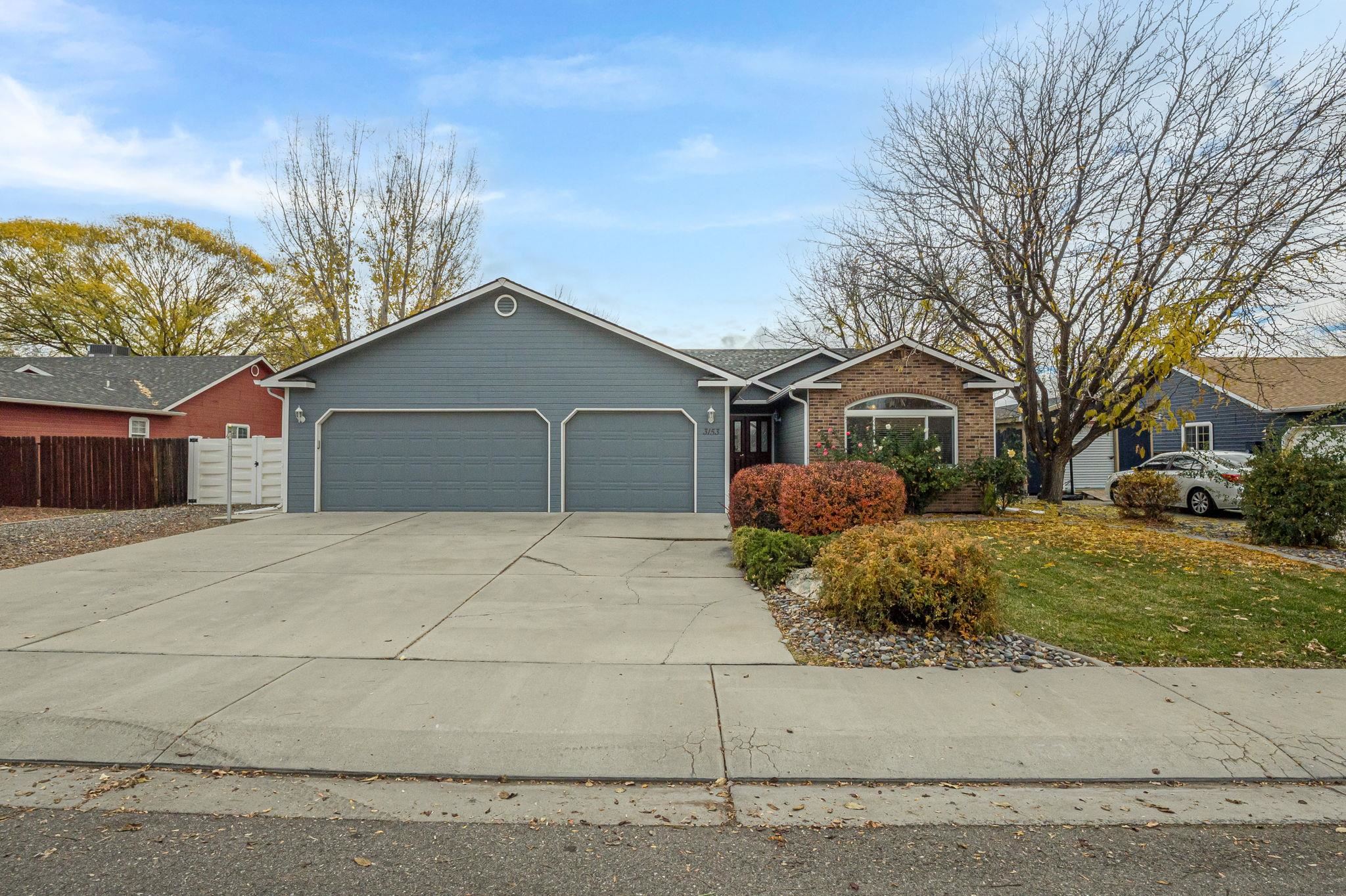 3153 Forrest Way Grand Junction, CO 81504 - Photo 1 of 42 a front view of a house with a yard and garage