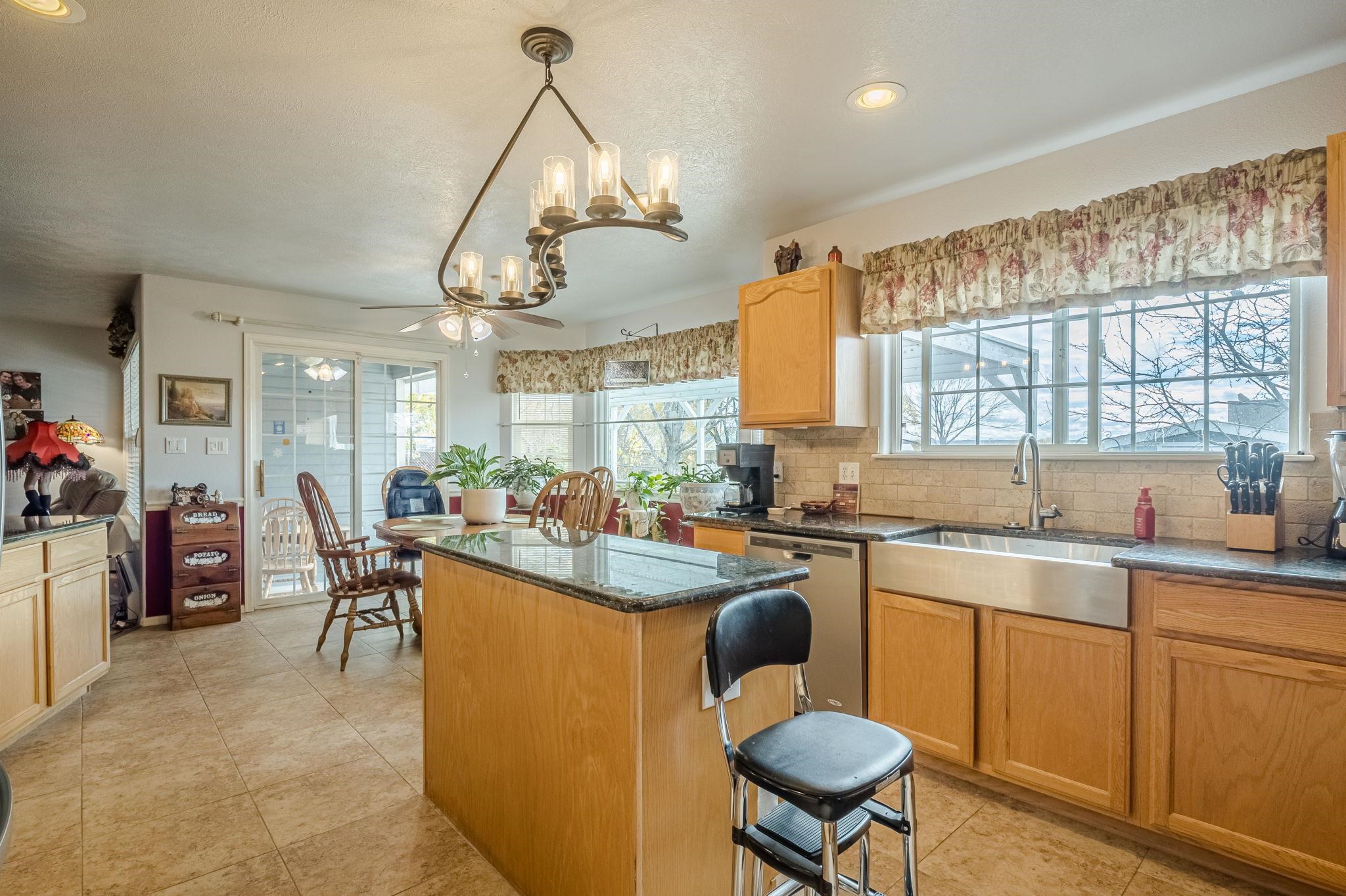 3153 Forrest Way Grand Junction, CO 81504 - Photo 14 of 42 a kitchen with a dining table chairs sink and cabinets