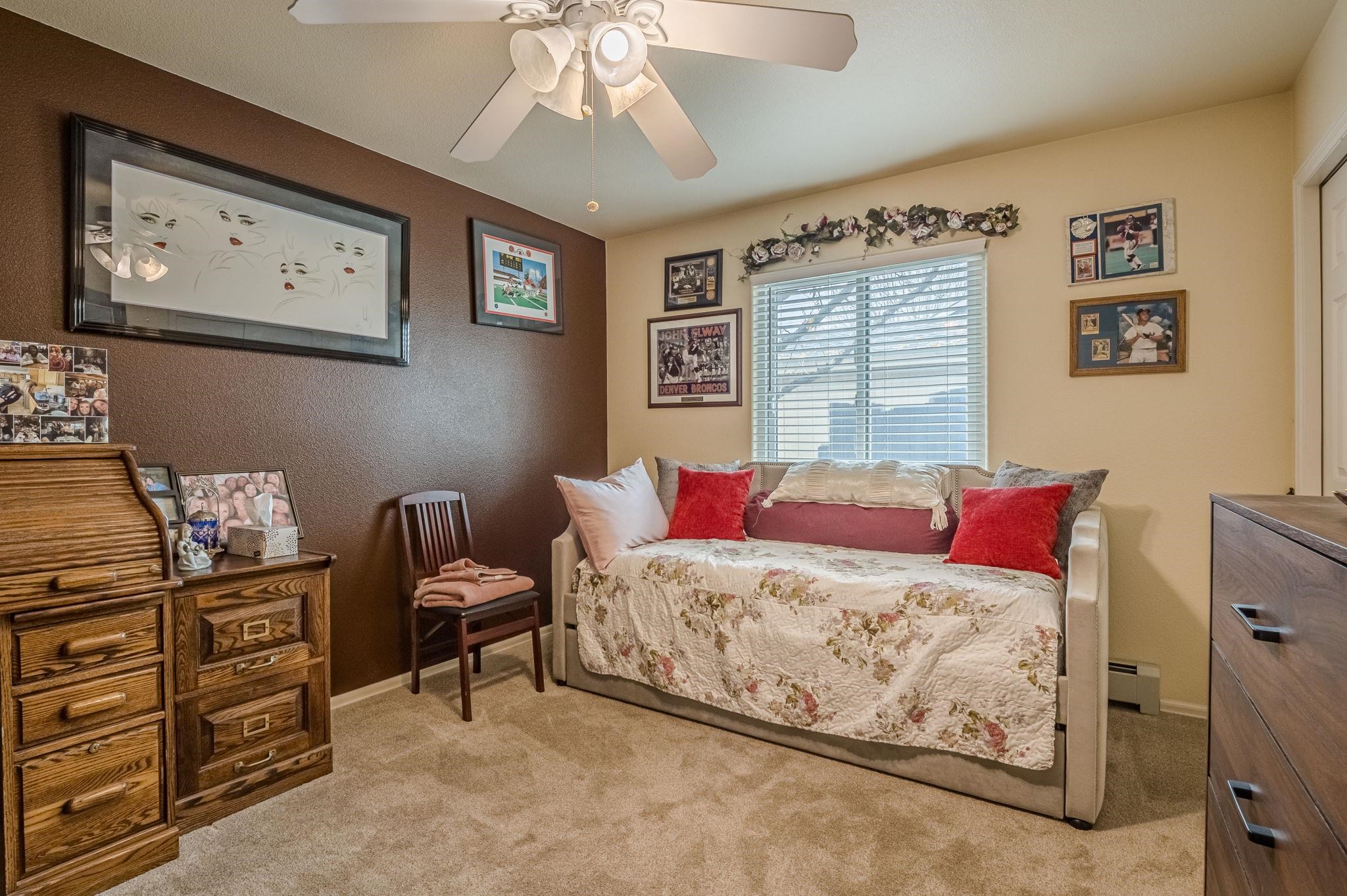3153 Forrest Way Grand Junction, CO 81504 - Photo 24 of 42 a bedroom with a bed and a chandelier