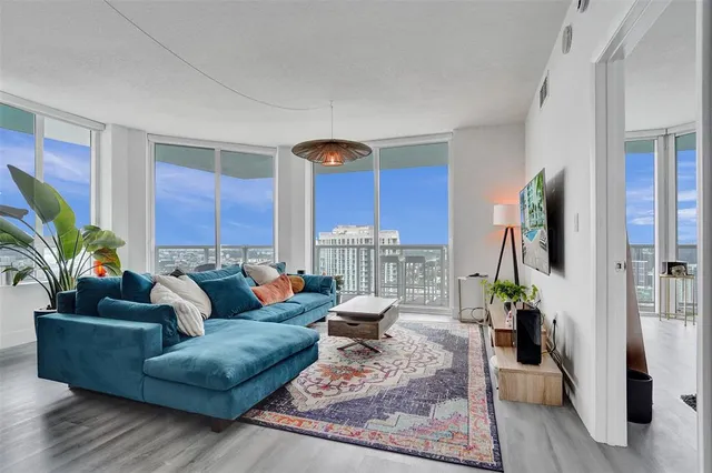 a living room with furniture potted plant and a large window