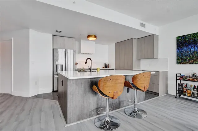 a kitchen with stainless steel appliances granite countertop a sink refrigerator and cabinets