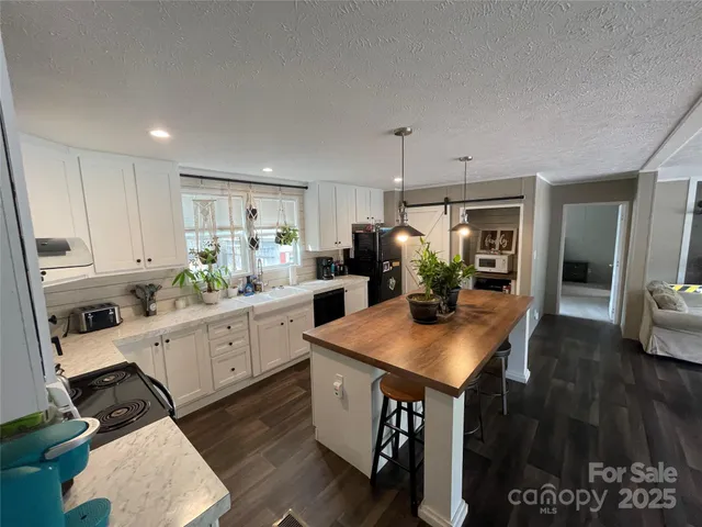 a kitchen with white cabinets appliances and wooden floor
