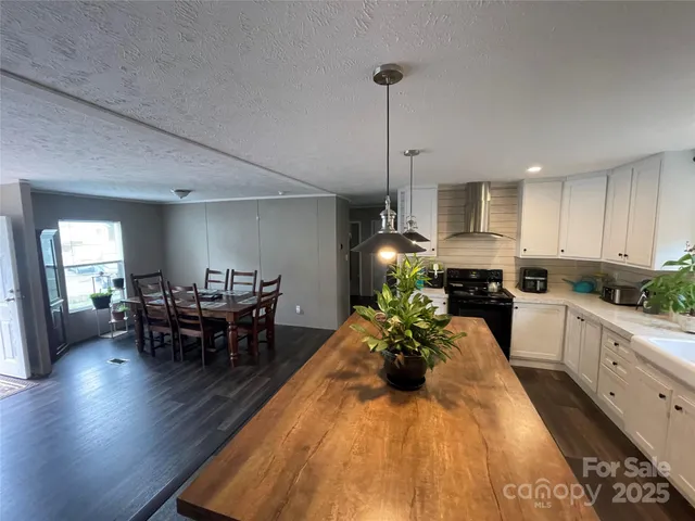 a kitchen with sink refrigerator dining table and chairs