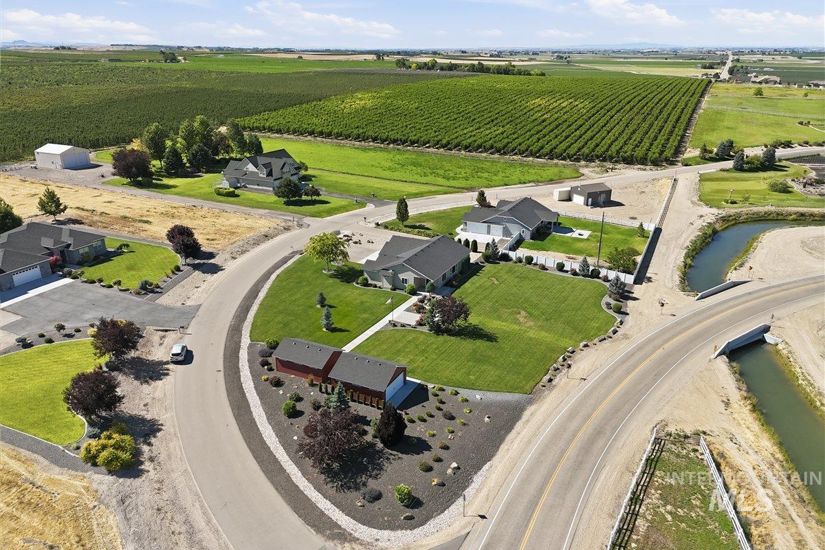 13496 Hockberger Ranch Road Caldwell, ID 83607 - Photo 38 of 40 Expansive property featuring a meticulously maintained lawn, mature landscaping, and a red outbuilding