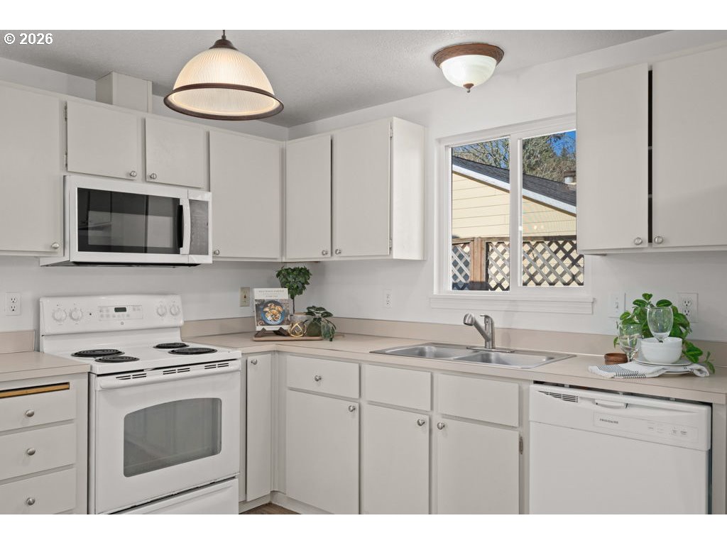 4482 Southwest 179th Avenue Beaverton, OR 97078 - Photo 11 of 37 a kitchen with stainless steel appliances a sink a stove a microwave a sink and cabinets