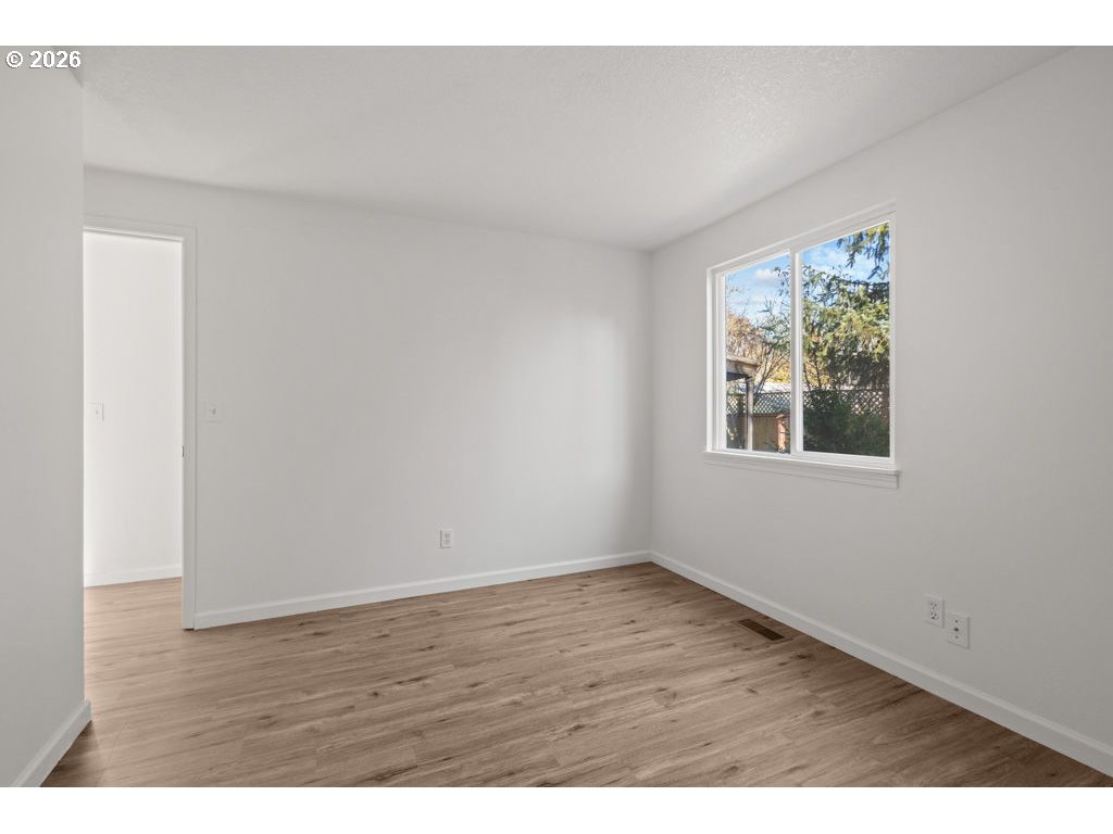 4482 Southwest 179th Avenue Beaverton, OR 97078 - Photo 22 of 37 a view of an empty room with wooden floor and a window