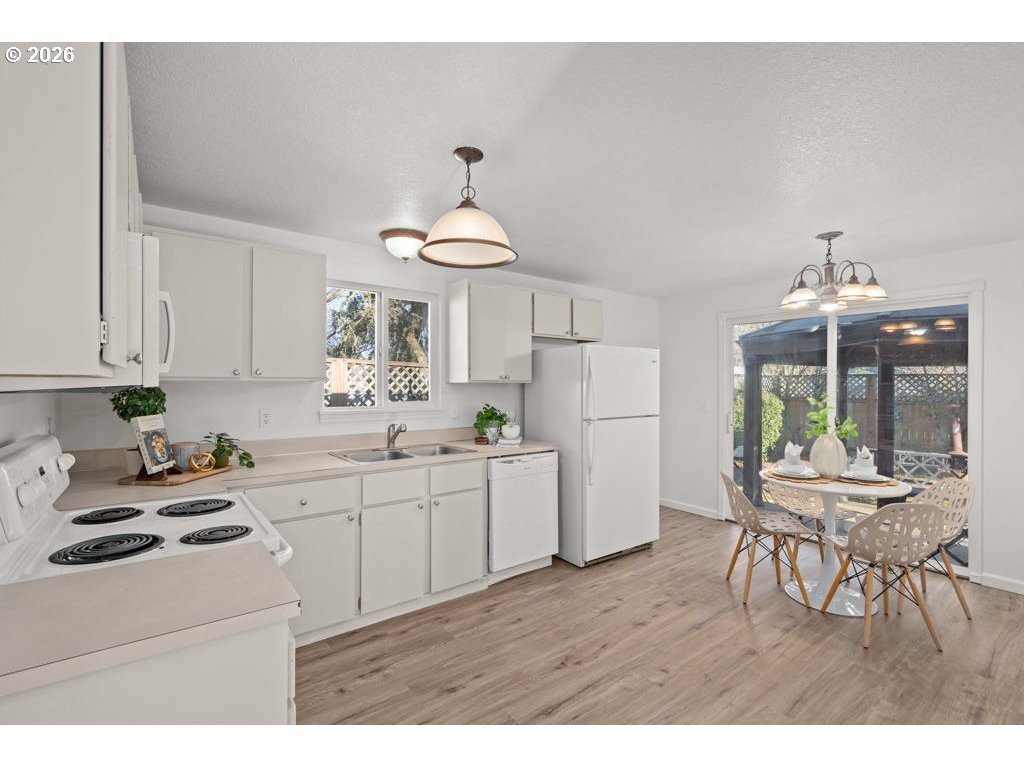 4482 Southwest 179th Avenue Beaverton, OR 97078 - Photo 10 of 37 a kitchen with a sink a stove a refrigerator and white cabinets