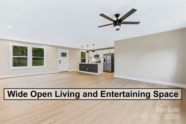 a view of a kitchen with wooden floor and a ceiling fan