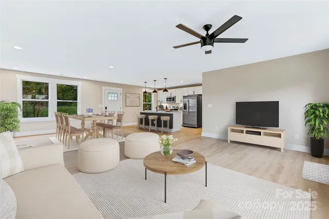 a living room with furniture kitchen view and a large window