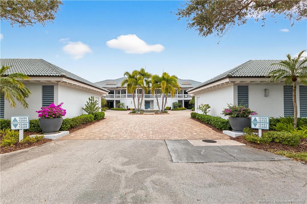 12500 Harbour Ridge Boulevard, Unit 48 Palm City, FL 34990 - Photo 3 of 28 a front view of a house with a yard and a garage