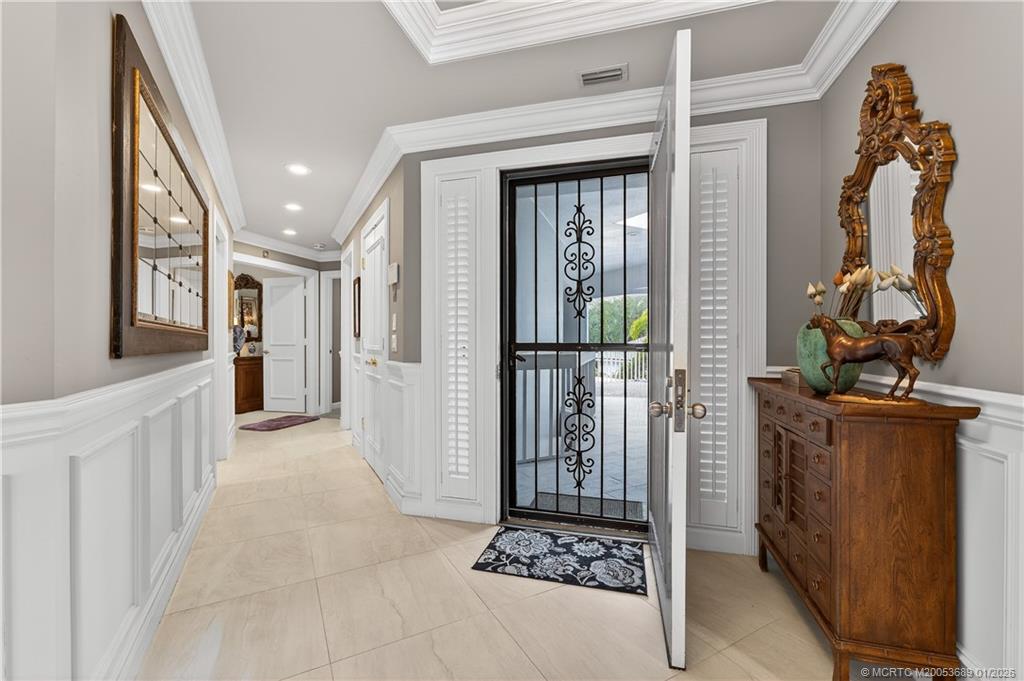 12500 Harbour Ridge Boulevard, Unit 48 Palm City, FL 34990 - Photo 4 of 28 a view of a hallway with wooden floor and a living room