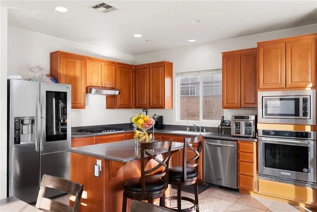 a kitchen with stainless steel appliances granite countertop a sink a stove and a refrigerator