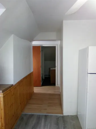 a view of a hallway with wooden floor and entryway