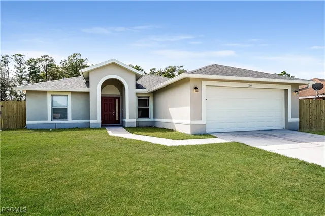 a front view of a house with a yard and garage