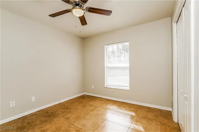 an empty room with a window and a fan