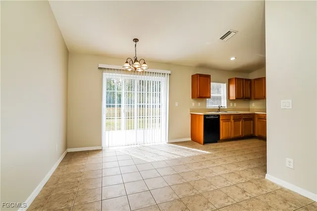 a view of a kitchen with a sink and dishwasher a stove top oven with wooden floor