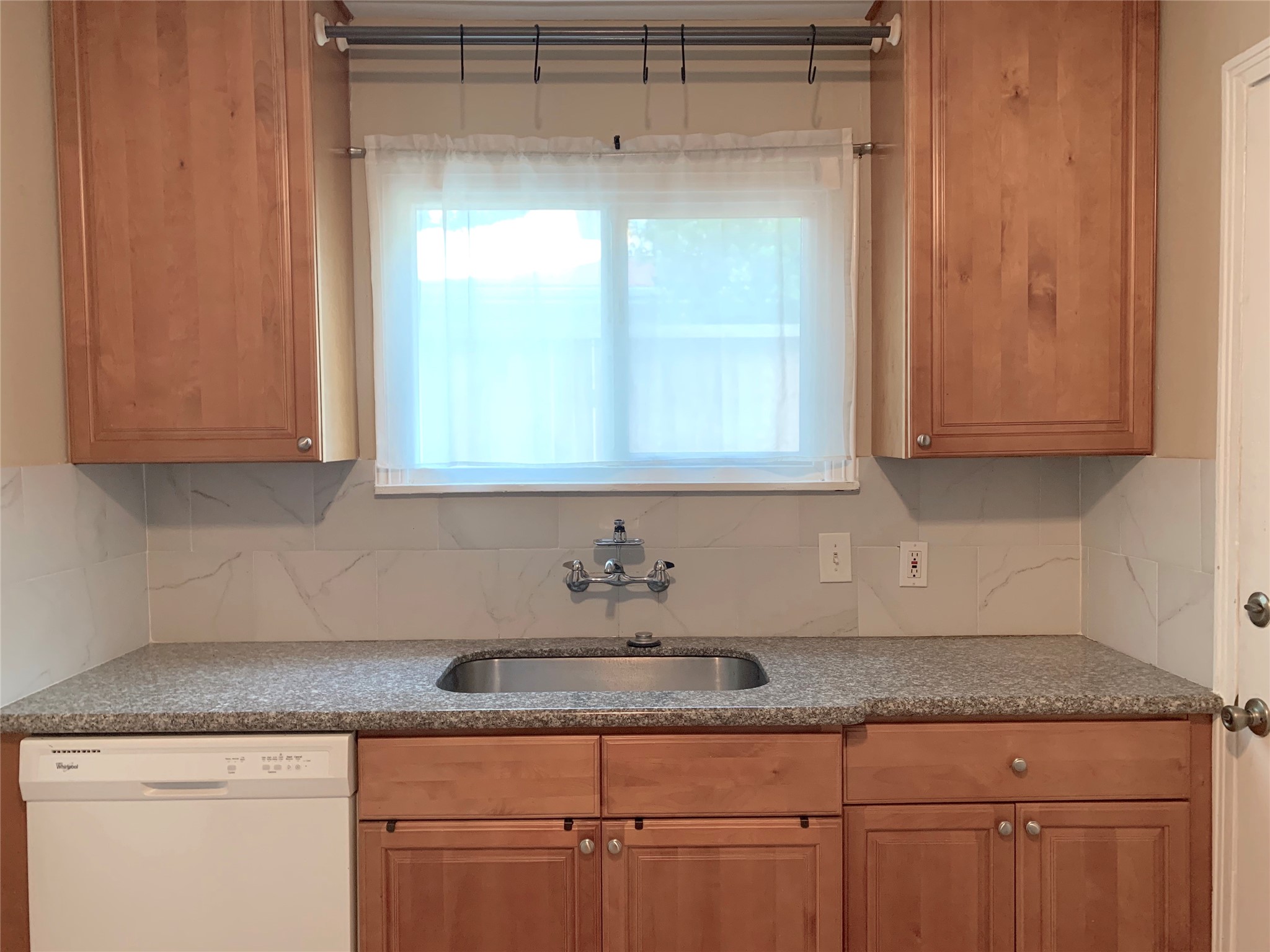307 Avondale Street, Unit 1 Houston, TX 77006 - Photo 7 of 22 Kitchen with granite countertop & tile backsplash. Stainless steel sink and Kitchen window with view. Disposal and dishwasher too. Brushed nickel hardware.