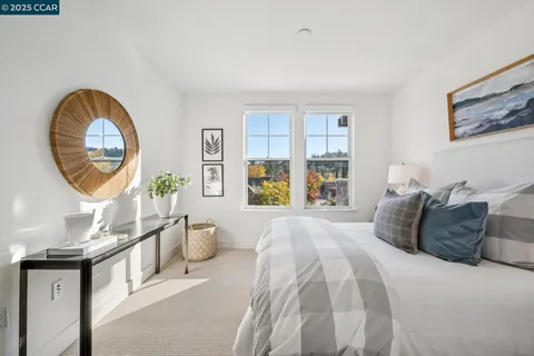 a bedroom with a bed a mirror and a large window