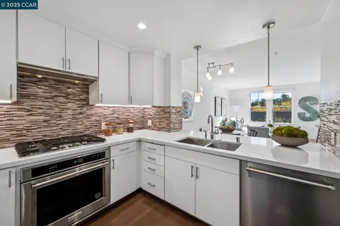 a kitchen with stainless steel appliances a sink a stove and cabinets