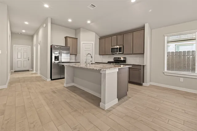 a view of kitchen with stainless steel appliances granite countertop a refrigerator and a sink